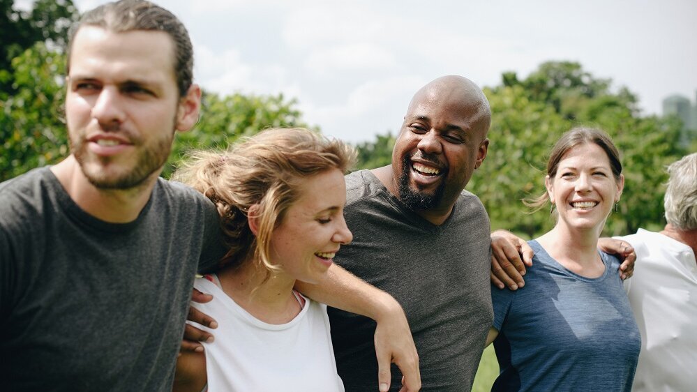 Diverse Menschen Arm in Arm in der Natur