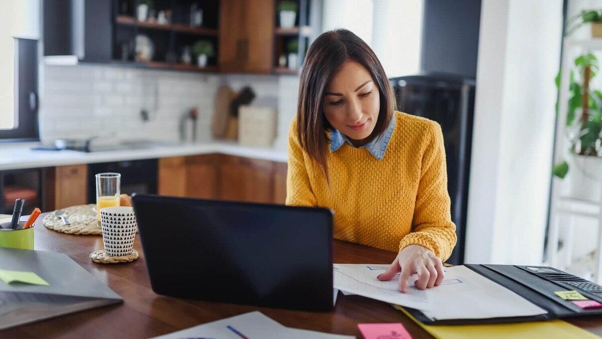 Eine Frau arbeitet im Homeoffice an ihrem Esstisch.
