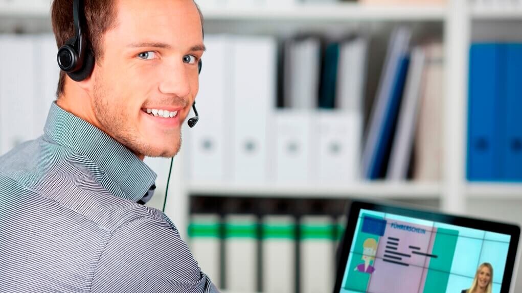 Junger Mann mit Kopfhörern am Laptop (Online-Unterweisungen)