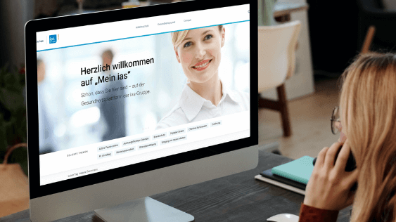 Plattform "Mein ias" Frau schaut auf den Bildschirm eines Computers mit der Startseite von "Mein ias"-Portal